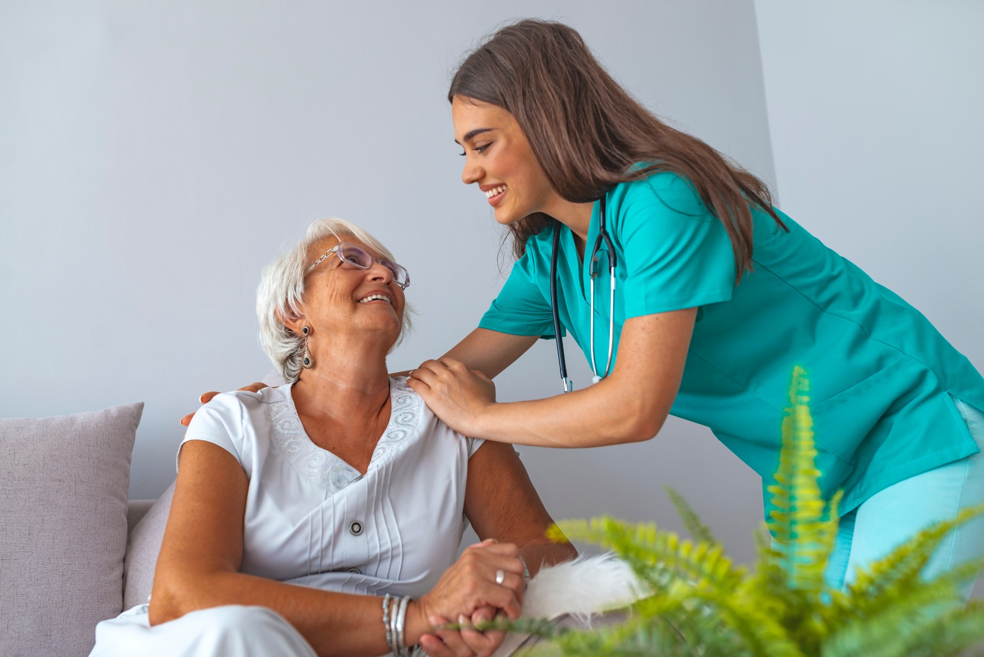 Happy senior woman laughing with her professional caretaker