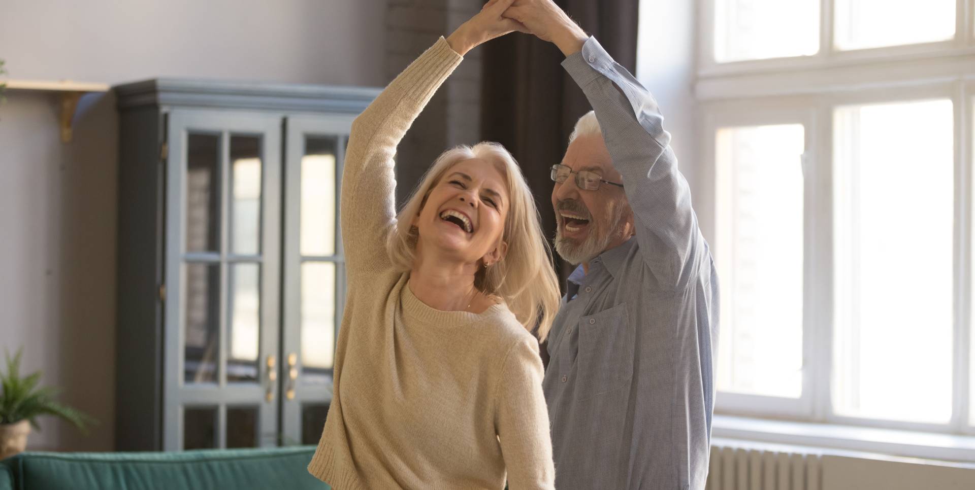 happy seniors dancing in their new senior apartment