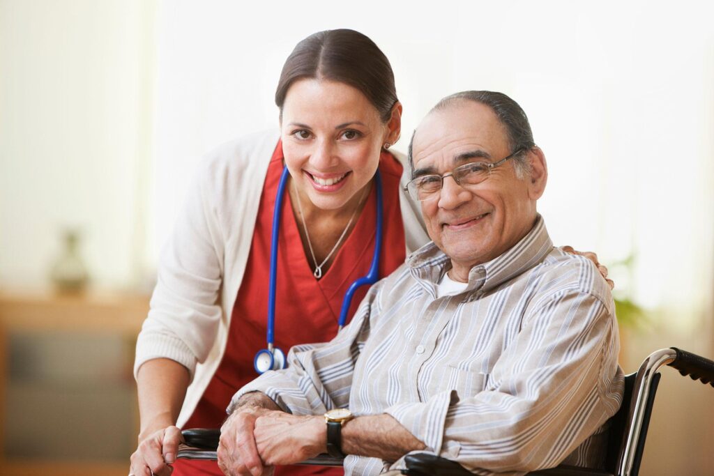 A senior man sitting in a wheelchair and his nurse next to him.