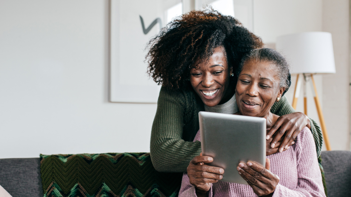 Adult daughter hugging senior mother from behind