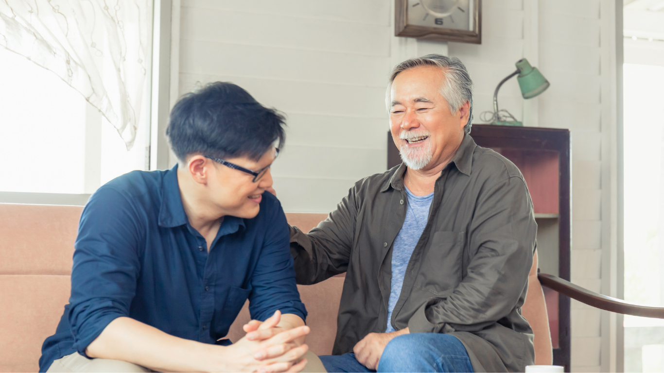 Adult son and senior father on couch