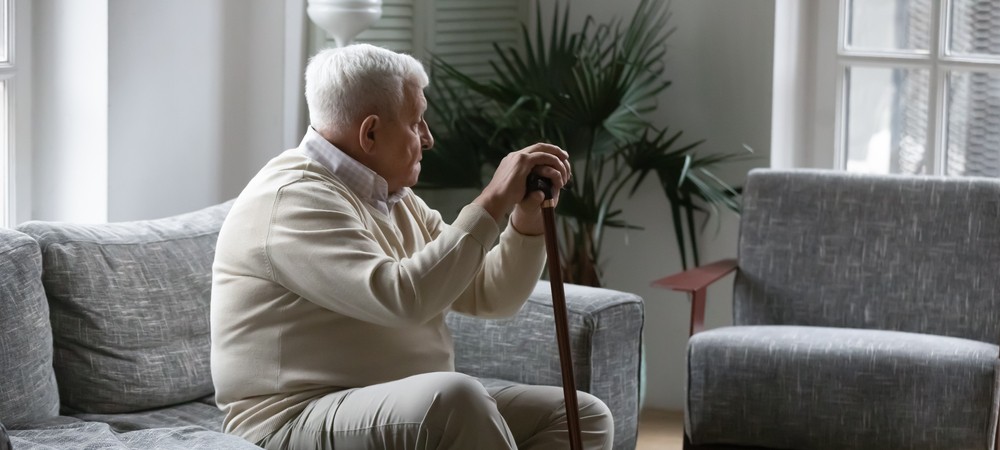 Thoughtful senior man sitting on his couch