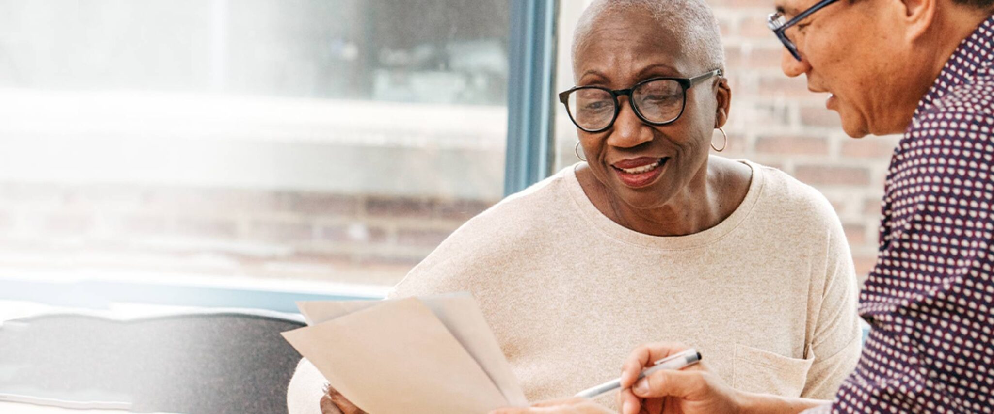 a senior woman looking over the paper work for moving into a senior living community