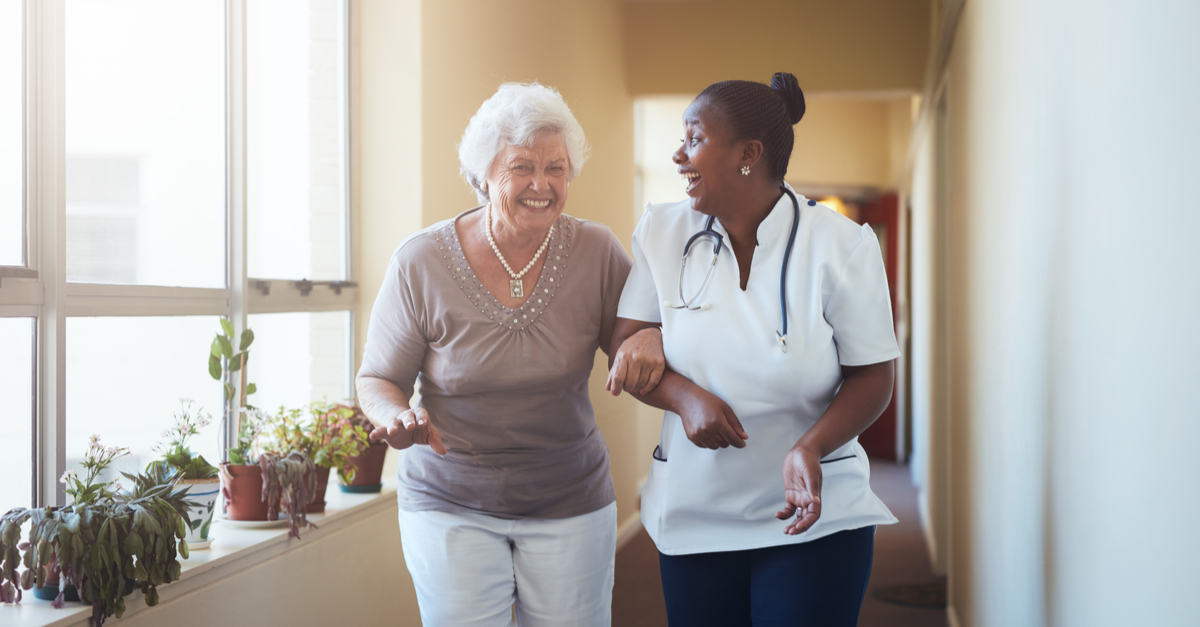 happy healthcare worker and senior woman walking together