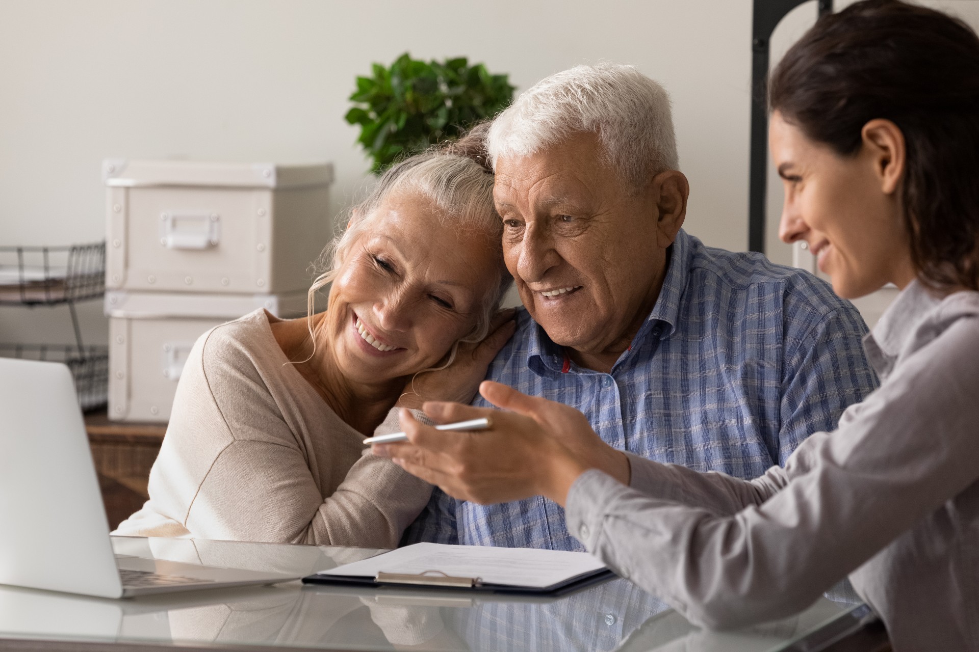 Female agent showing housing options to a happy senior couple