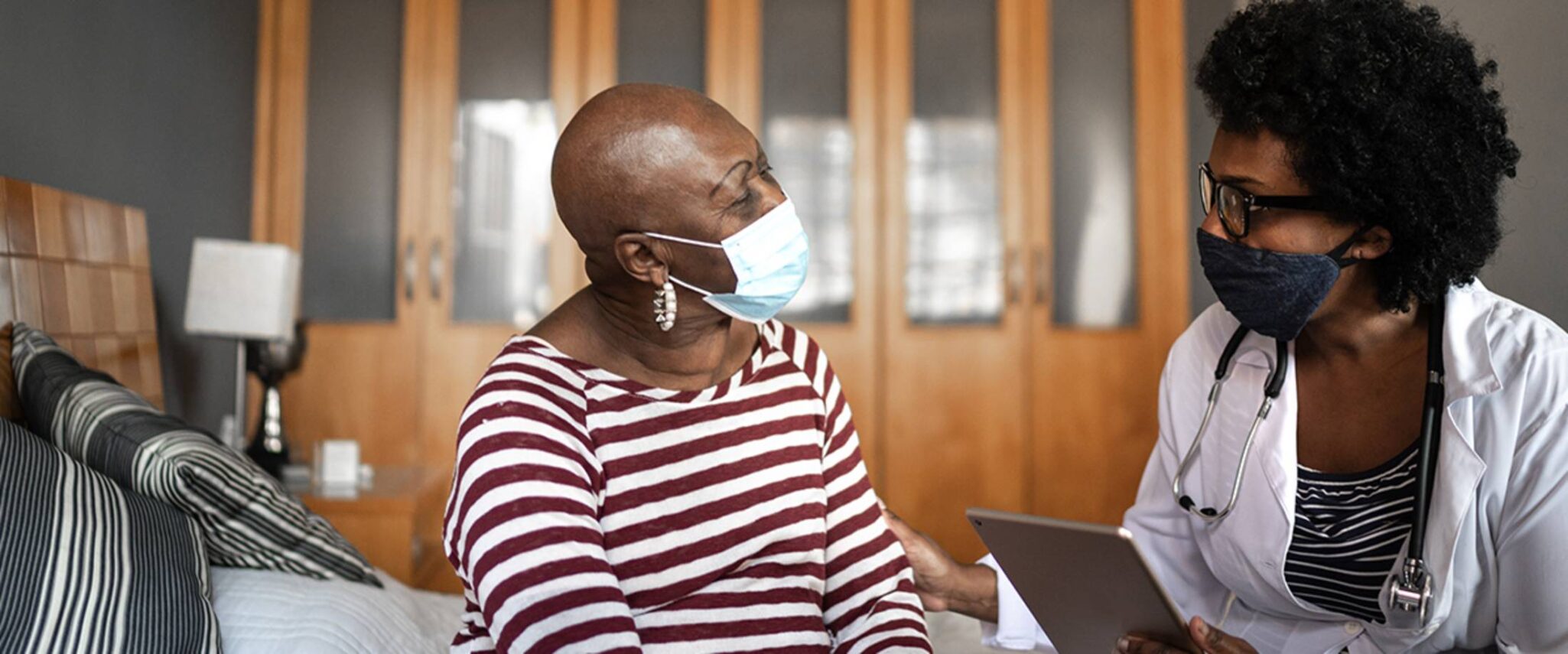 Healthcare worker talking with an elderly patient at a skilled nursing home