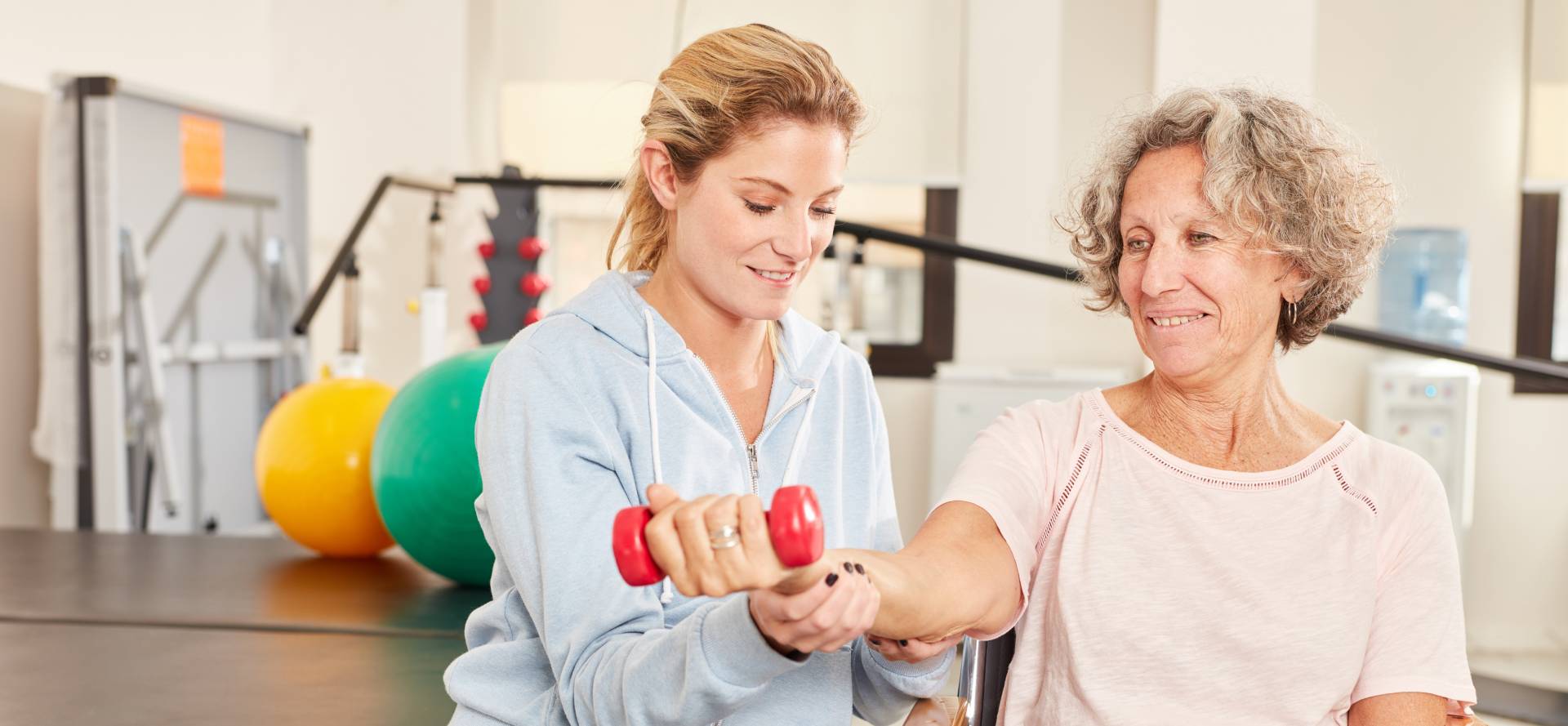physical therapist assisting a senior with an exercise in senior rehabilitation
