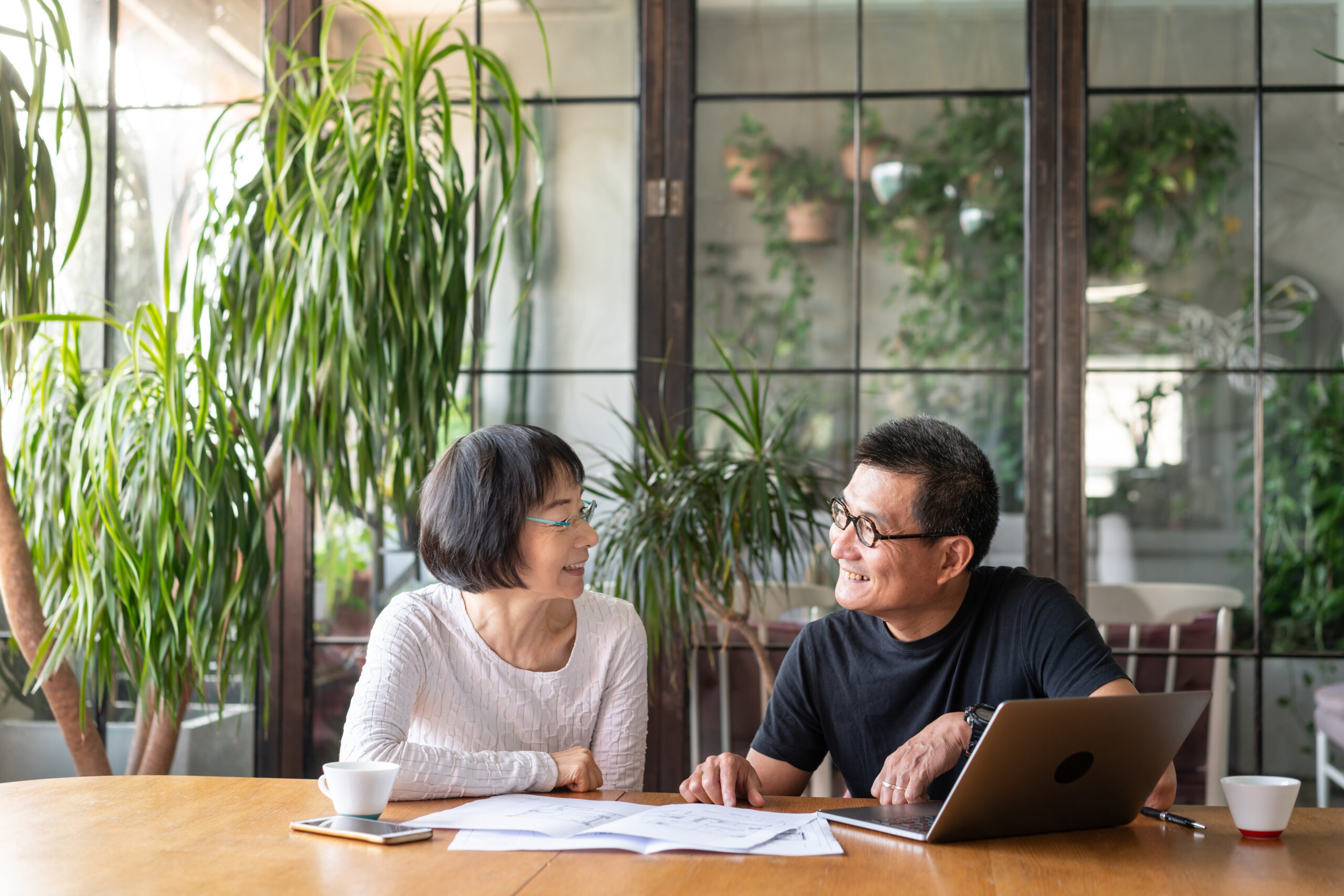 A couple sitting at a kitchen table looking at paperwork